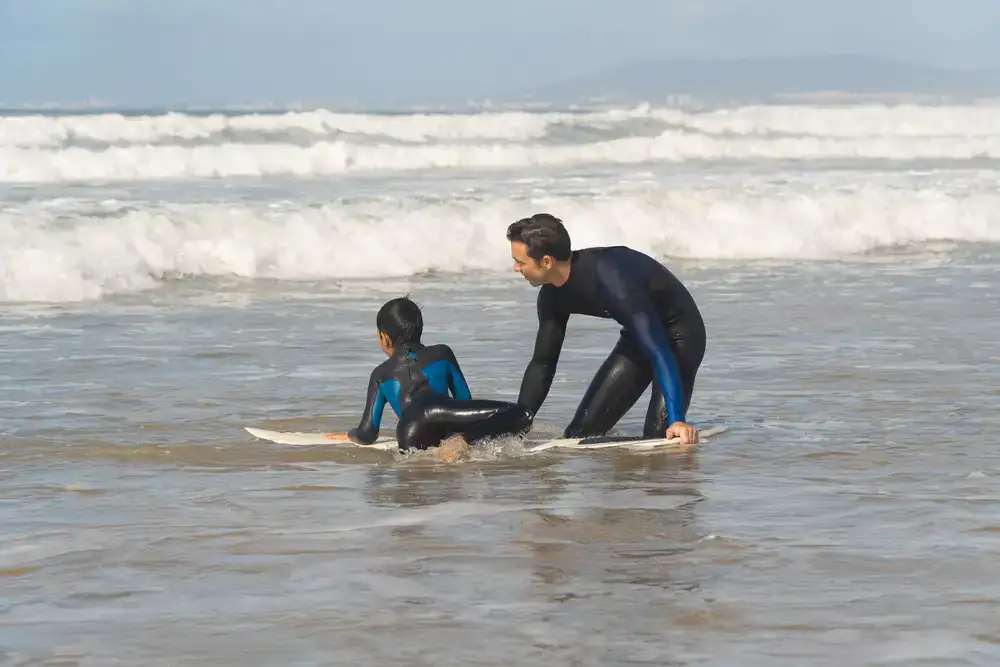 Instructor de surf guiando a un alumno en el agua