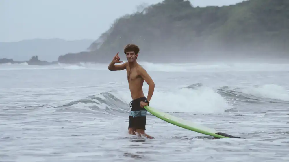 Alumno con tabla de surf